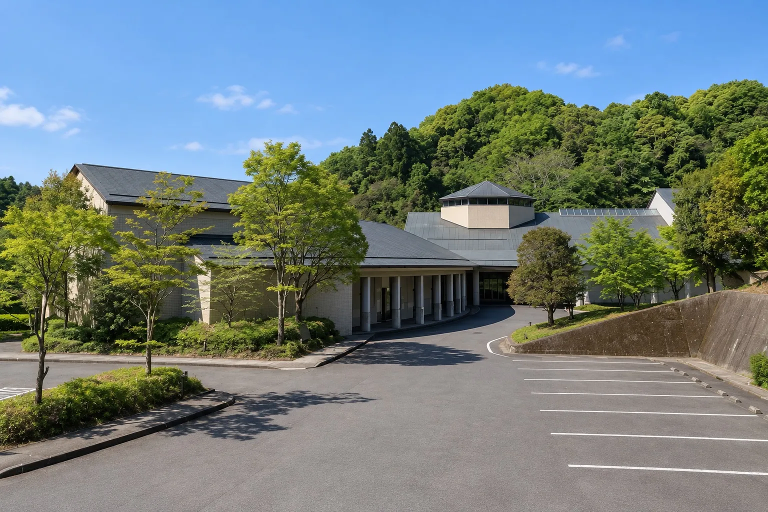 長南聖苑の外観。緑の山を背にした低い建物と車寄せ（イメージ）